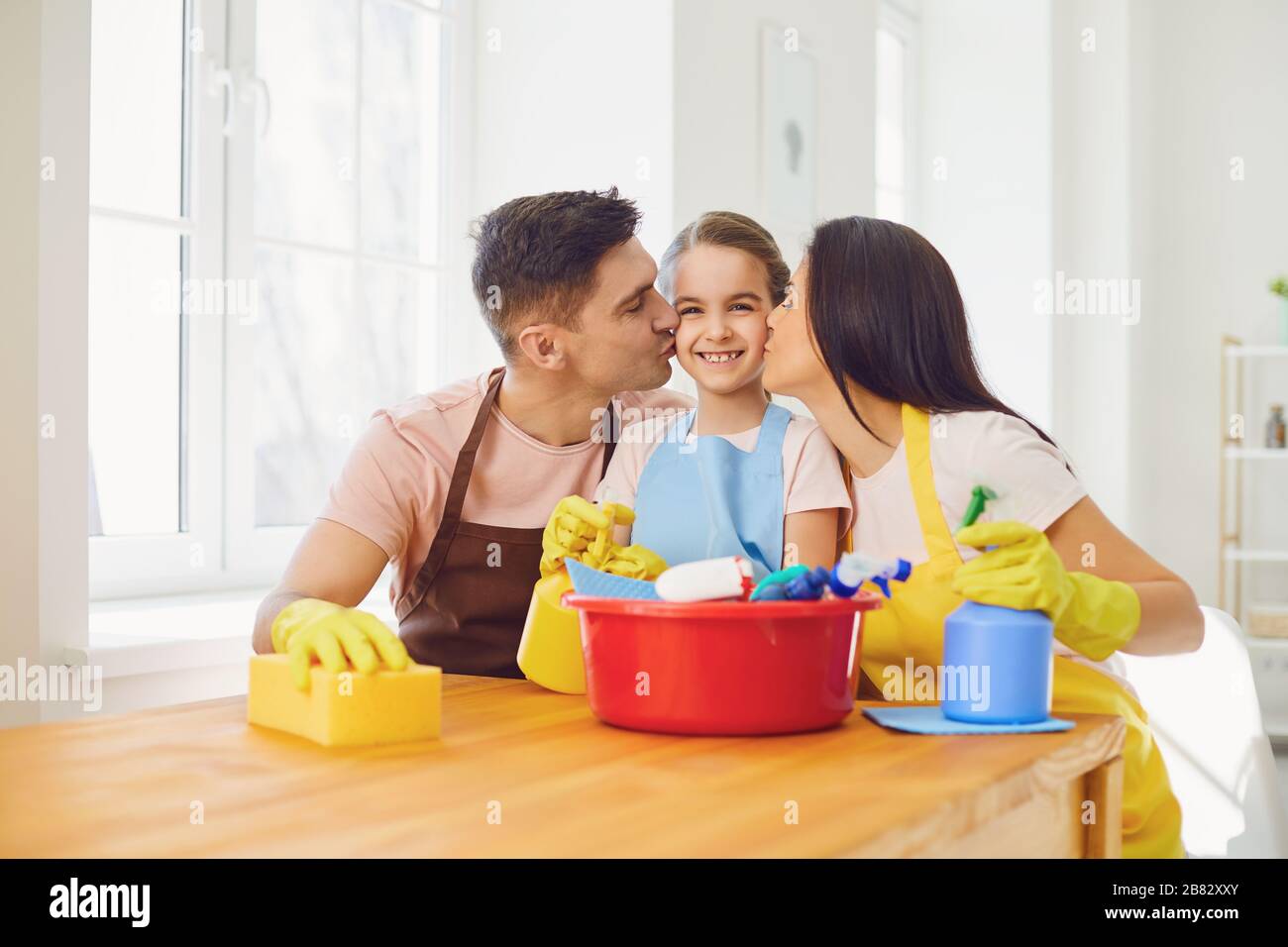 Die glückliche Familie reinigt das Zimmer im Haus. Stockfoto