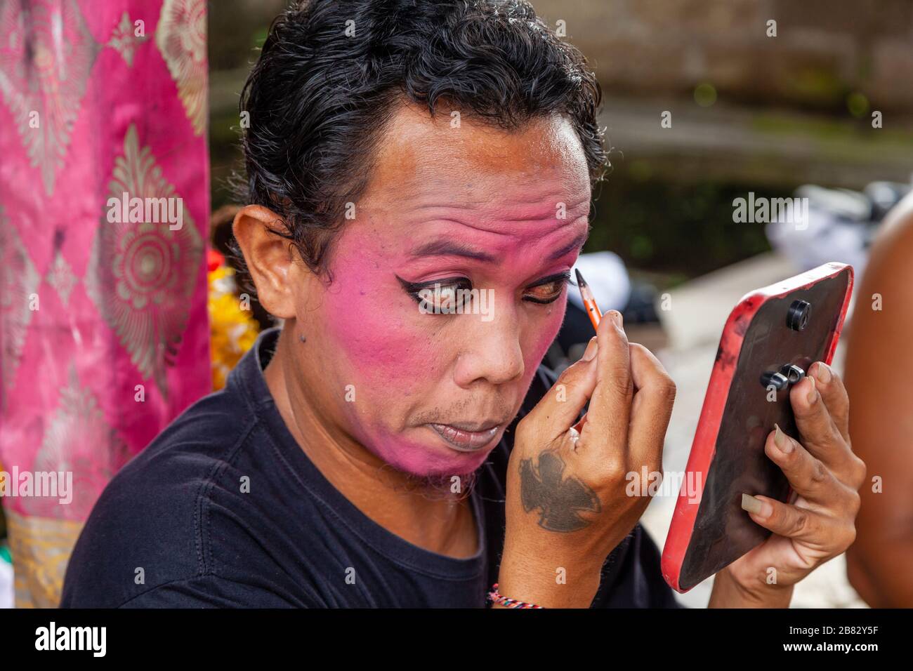 Ein männlicher Darsteller trifft Make Up zu, bevor er in EINER traditionellen balinesischen Barong und Kris Dance Show, Batabulaan, Bali, Indonesien, auftrat. Stockfoto