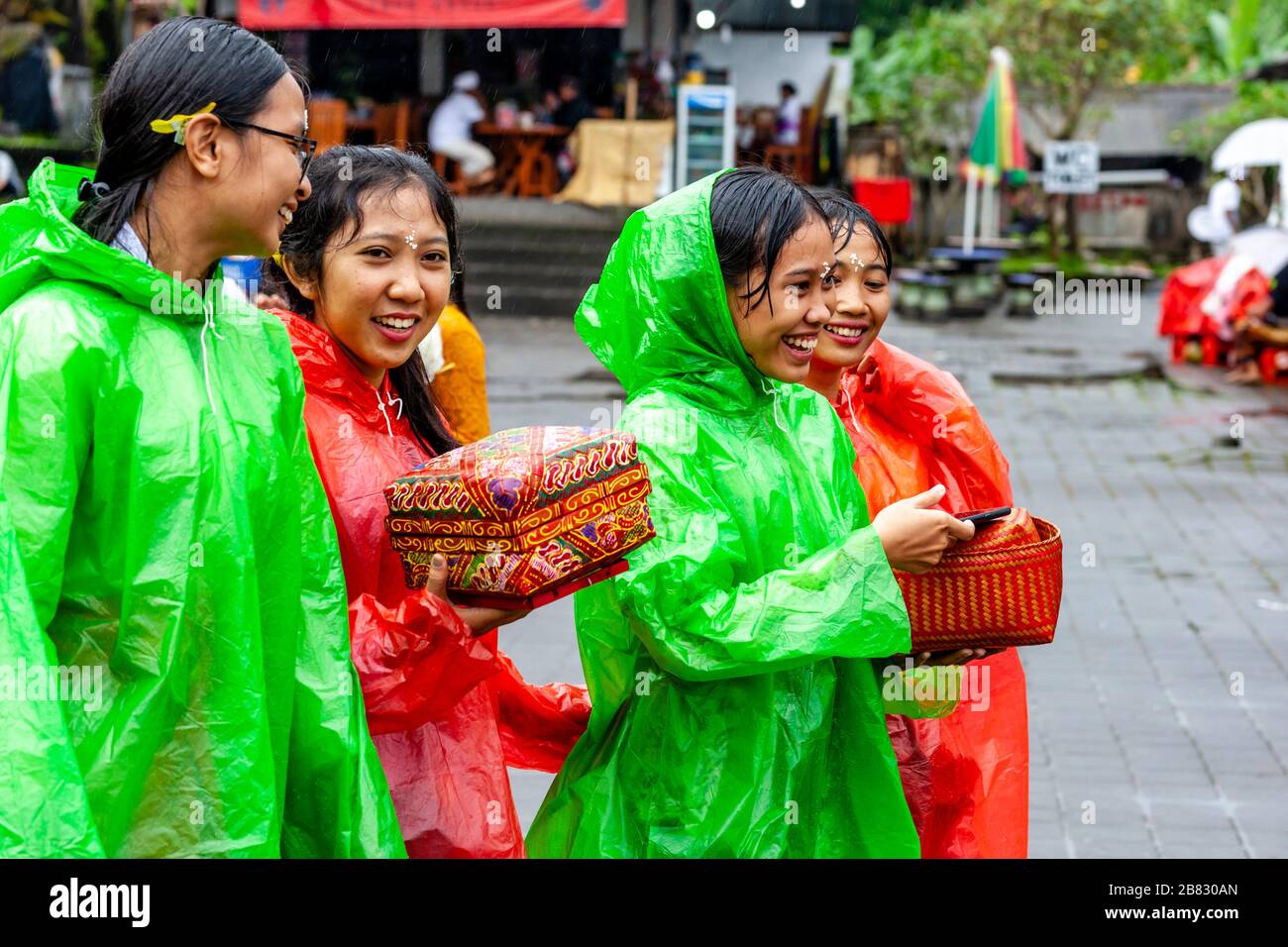 Junge Balinesische Hindu-Frauen Kommen Zur Zeremonie Batara Turun Kabeh Im Regen, Besakih-Tempel, Bali, Indonesien. Stockfoto