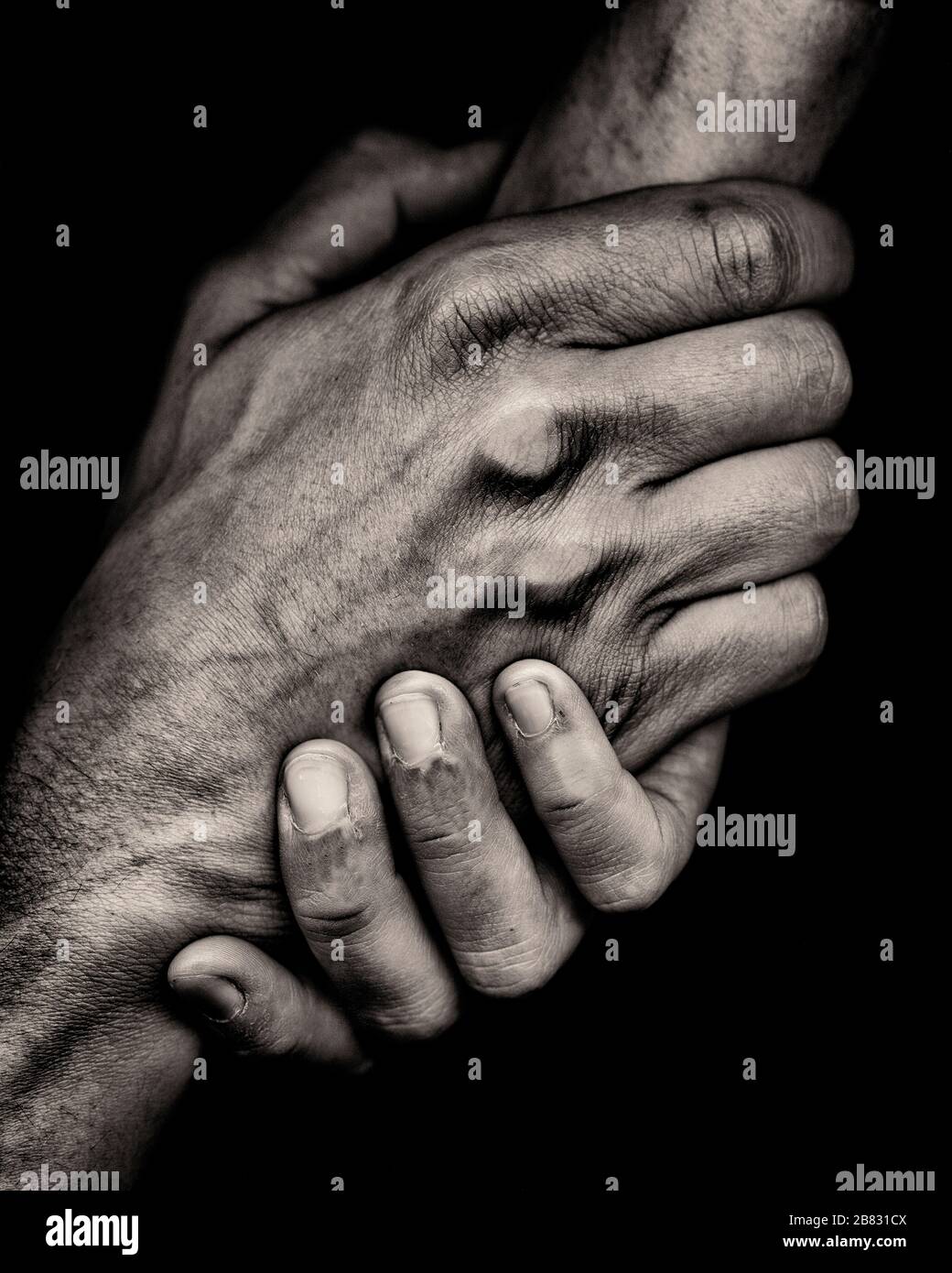 Zwei gekleppte Hände vor schwarzem Hintergrund Stockfoto