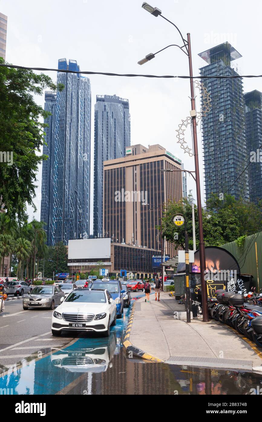 Kuala Lumpur, Malaysia - 25. November 2019: Straßenansicht der Innenstadt von Kuala Lumpur, einfache Menschen und Autos sind nach Regen auf nasser Straße Stockfoto