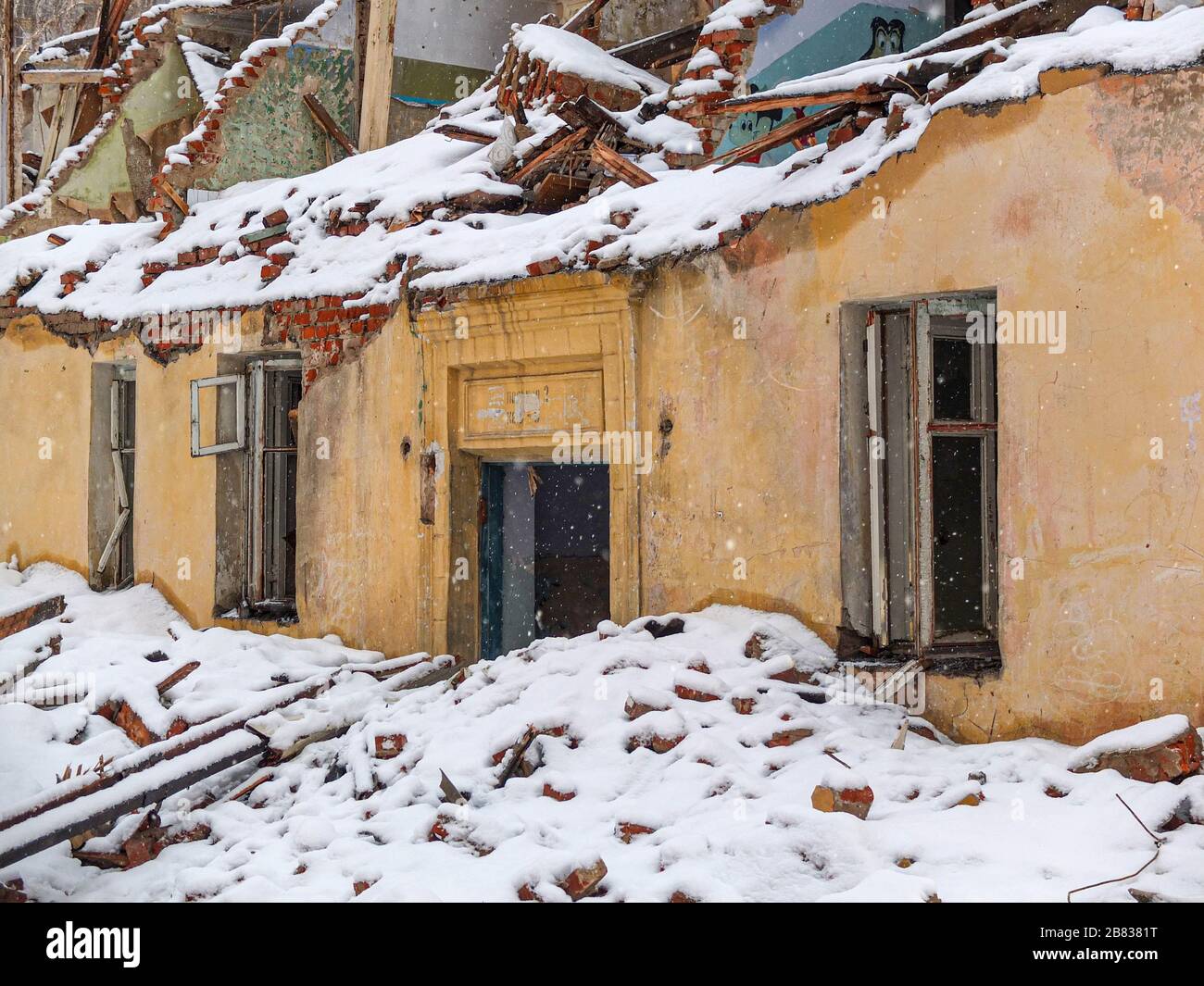 Altes Ziegelhaus im Winter bei Schneefall zerstört Stockfoto