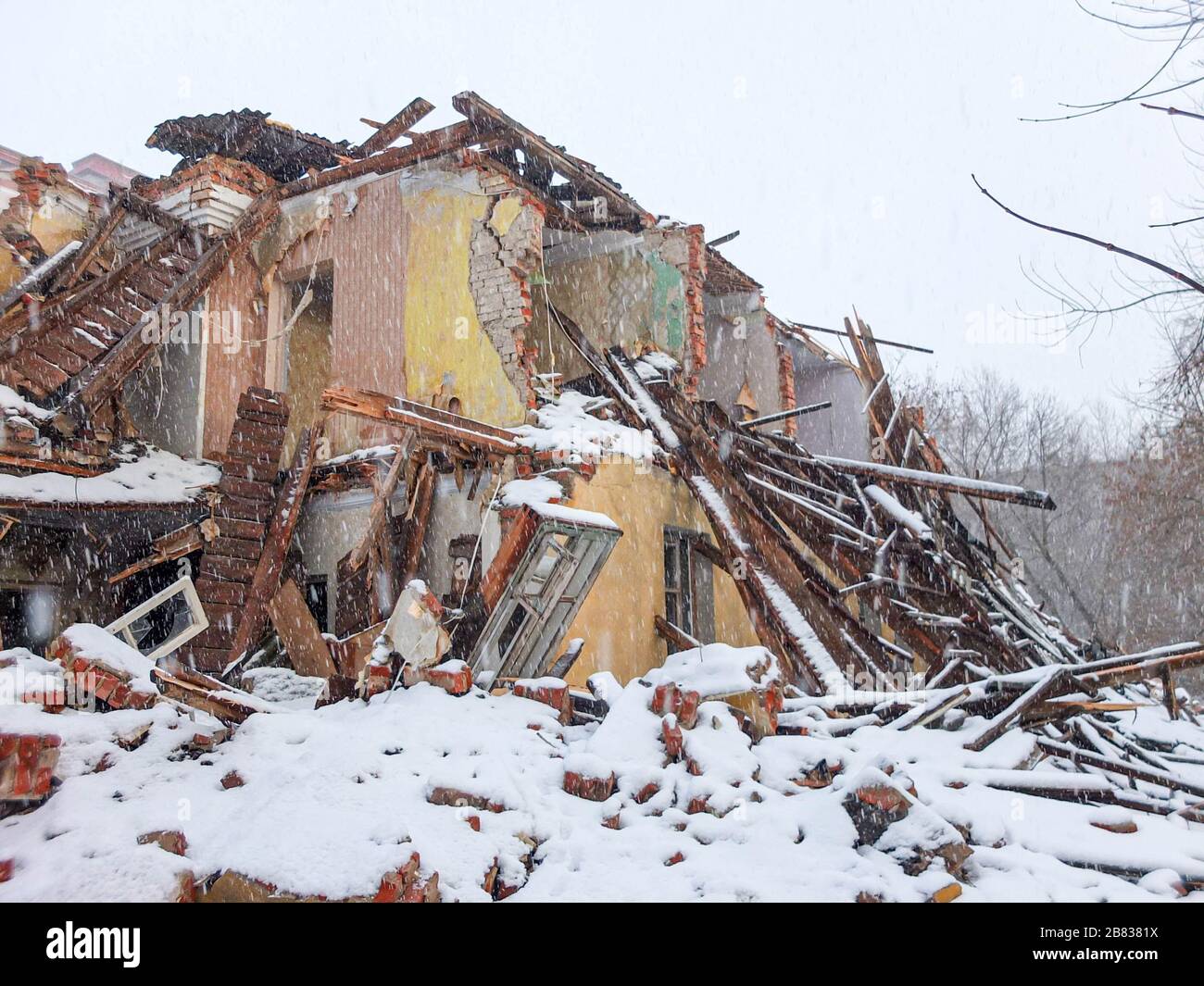 Altes Ziegelhaus im Winter bei Schneefall zerstört Stockfoto