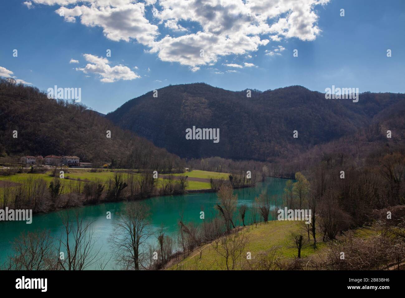 Weitwinkelaufnahme vom Dorf Prilesje im Winterfrühling Wechsel der Zeit zum Fluss Soca in ruhiger Kurve zum Kraftwerk in Solkan Stockfoto