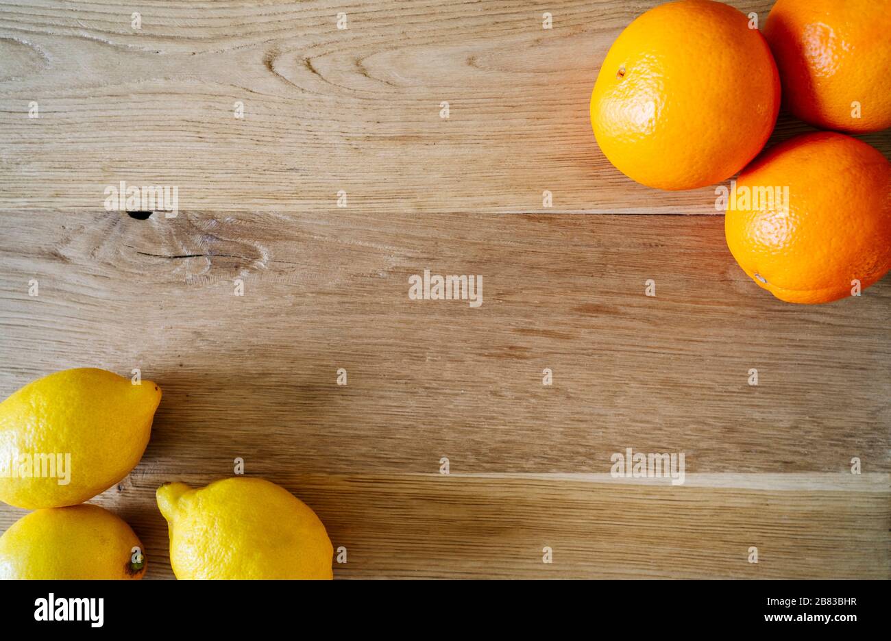 Orangen und Zitronen auf Holzhintergrund mit Platz für Text. Zitrusfrüchte für Saft Stockfoto