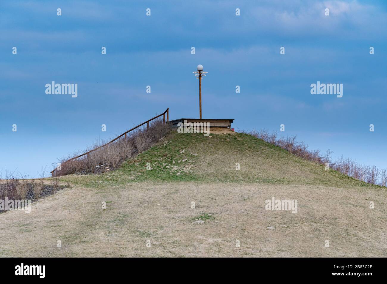 Oben auf dem kleinen Grashügel mit Schild und Zeiger auf der Oberseite Stockfoto