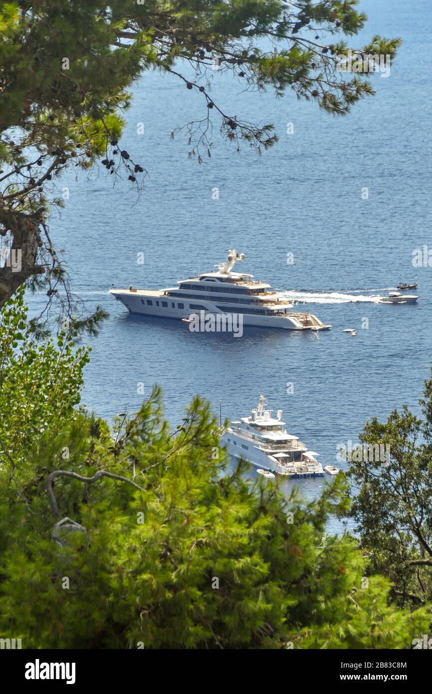 INSEL CAPRI, ITALIEN - AUGUST 2019: Luxuriöse Superyacht vor der Küste Capris. Die Aussicht wird von Bäumen umrahmt Stockfoto