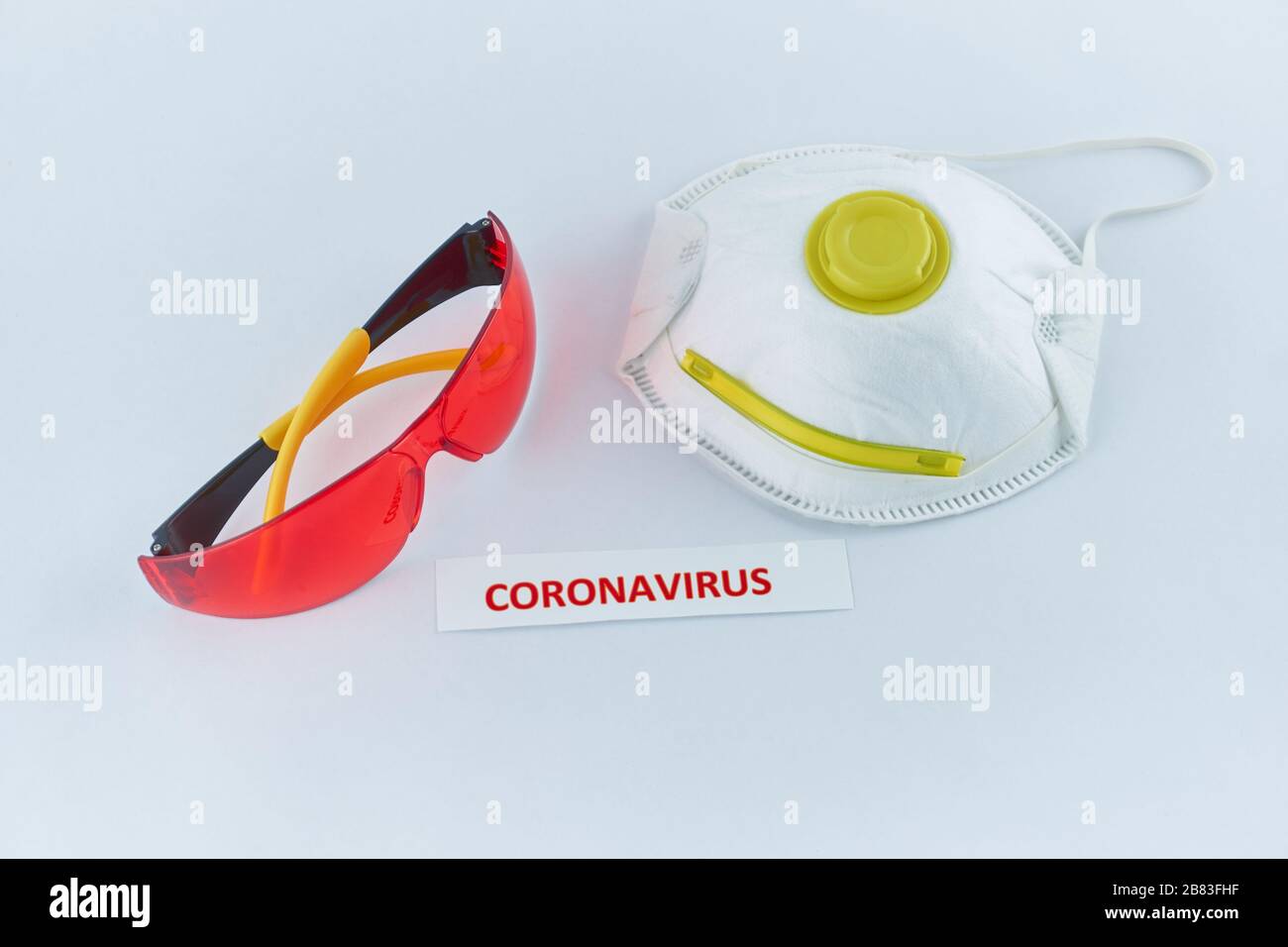 Coronavirus-Etikett neben Schutzkleidung Stockfoto