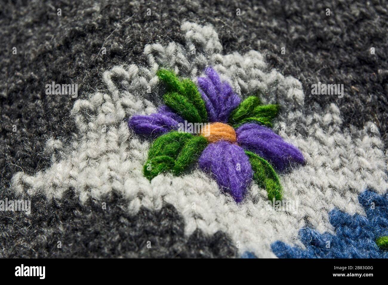 Eine schöne Zierde in Form einer Blume an einem Winterpullover. Stockfoto