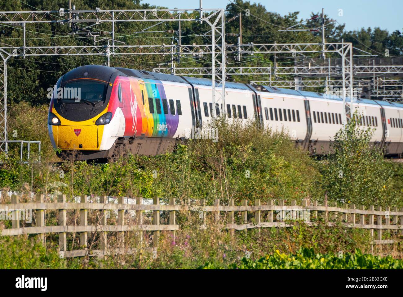 Virgin Class 390, Pendolino, elektrischer Neigezug in Regenbogenfarben, der schwulen Stolz feiert, vorbei an Esenhall, in der Nähe von Rugby, Warwickshire, England Stockfoto