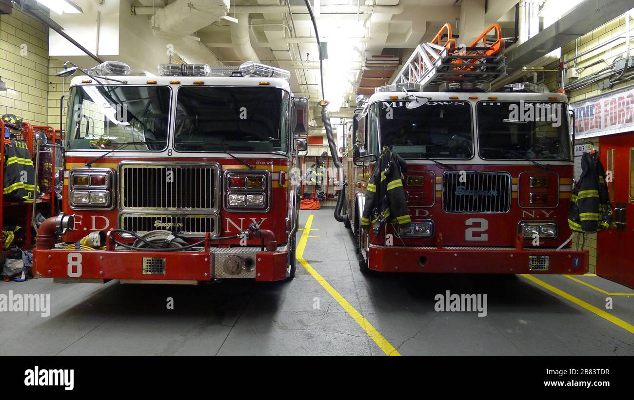 Zwei in der Feuerwache geparkte Einsatzfahrzeuge der New Yorker Feuerwehr Stockfoto