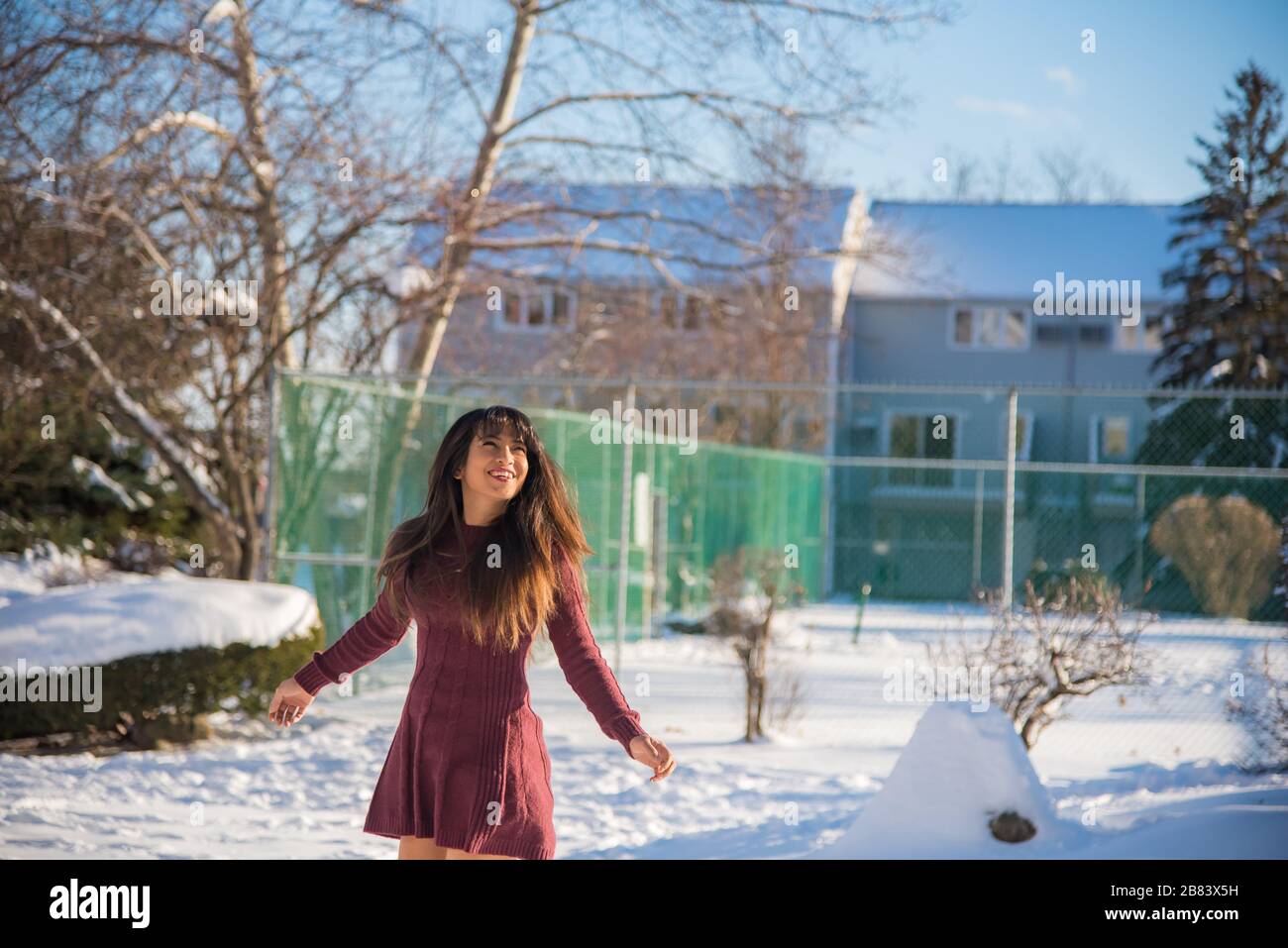 Frau, die nach dem Schneesturm am sonnigen Tag Spaß hat und Schnee genießt Stockfoto