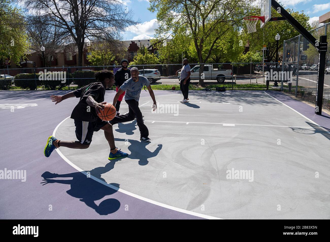 Sacramento, CA, USA. März 2020. Die Freunde Exodus Rogers, David B., Brian Little und Chris Wilson spielen Basketball im Roosevelt Park während des Ausbruchs der Coronavirus Pandemie am Donnerstag, den 19. März 2020 in Sacramento. Kredit: Paul Kitagaki Jr./ZUMA Wire/Alamy Live News Stockfoto