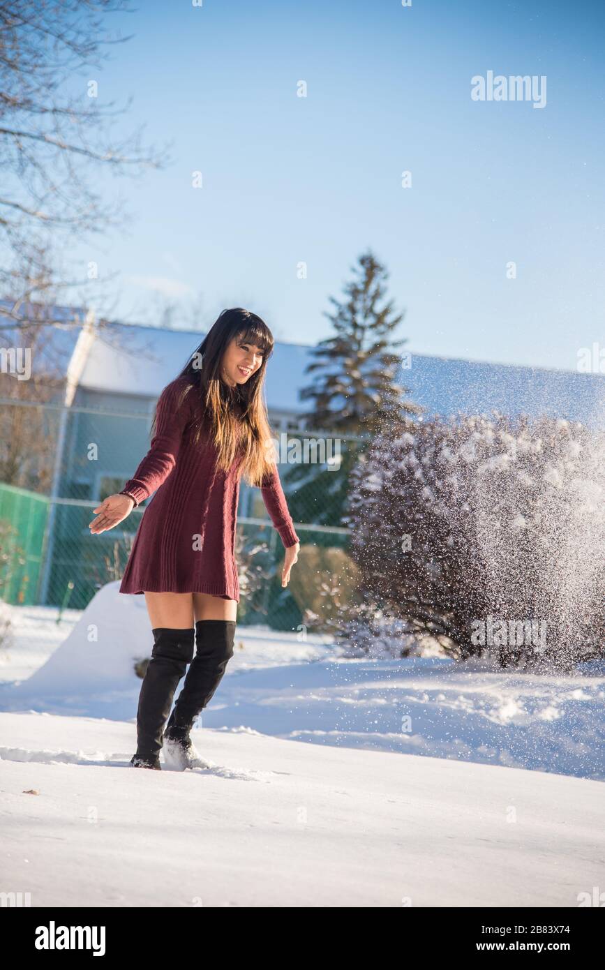 Frau, die nach dem Schneesturm am sonnigen Tag Spaß hat und Schnee genießt Stockfoto
