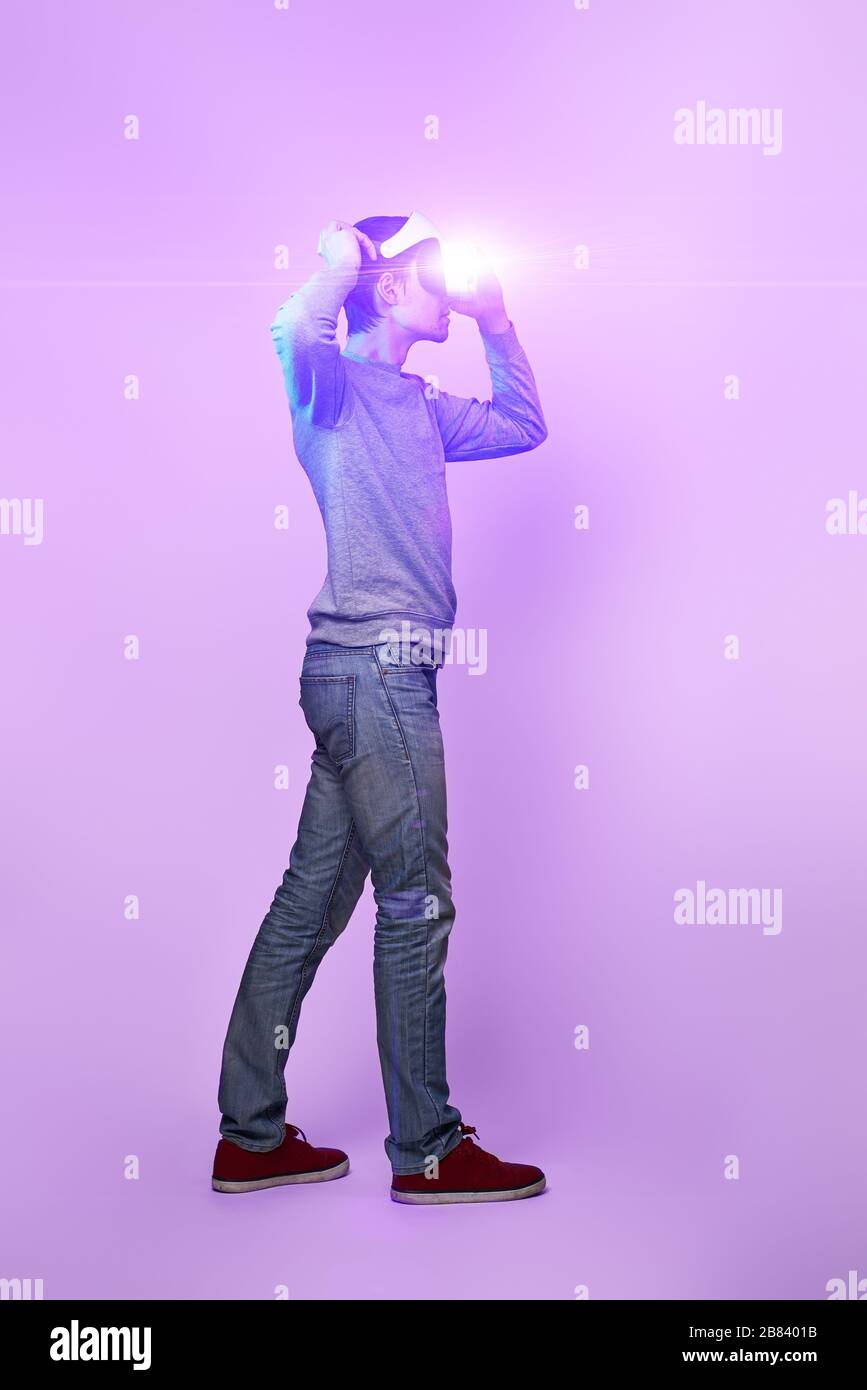 Mann mit Virtual reality Headset. Konzept der virtuellen Realität, Spiele, Unterhaltung und Kommunikation. Bild in der modernen Neon farbe Gamma Stockfoto