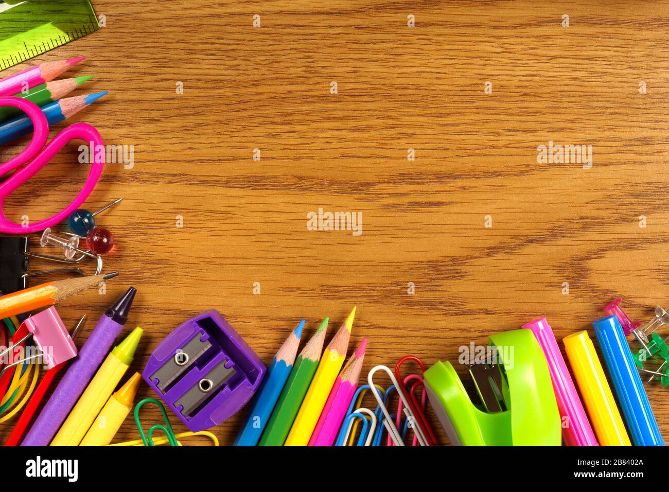 Die Schule versorgt den unteren Eckrand auf einem Holzschreibtisch Stockfoto