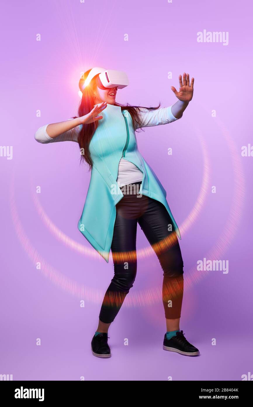 Frau mit Virtual reality Headset. Konzept der virtuellen Realität, Spiele, Unterhaltung und Kommunikation. Bild in der modernen Neon farbe Gamma. Stockfoto
