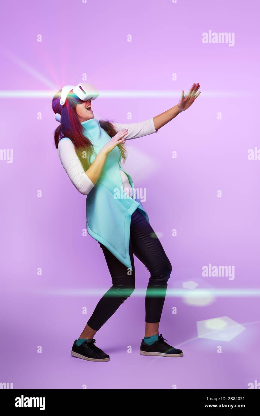Frau mit Virtual reality Headset. Konzept der virtuellen Realität, Spiele, Unterhaltung und Kommunikation. Bild in der modernen Neon farbe Gamma. Stockfoto