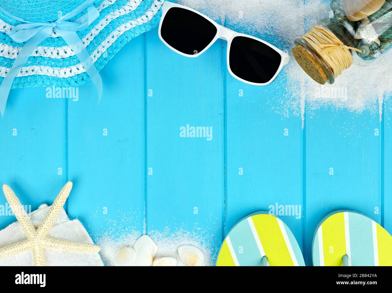 Sommer doppelte Grenze von Strandartikeln und Meeresschalen auf blauem Holzgrund Stockfoto