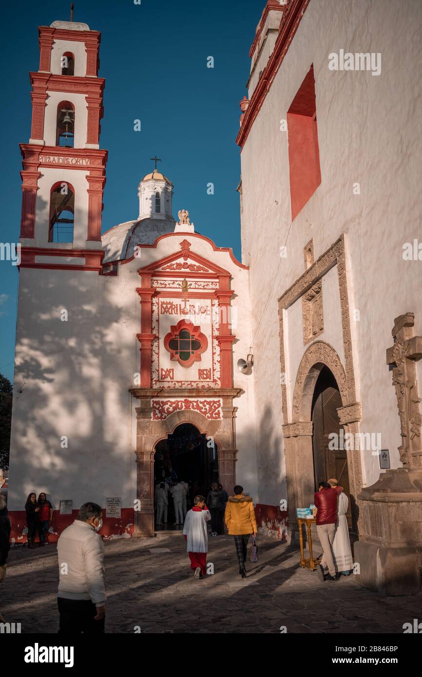 Mann, der mit Masken spaziert und Menschen täglicher Aktivitäten außerhalb einer Kirche nachgehen Stockfoto