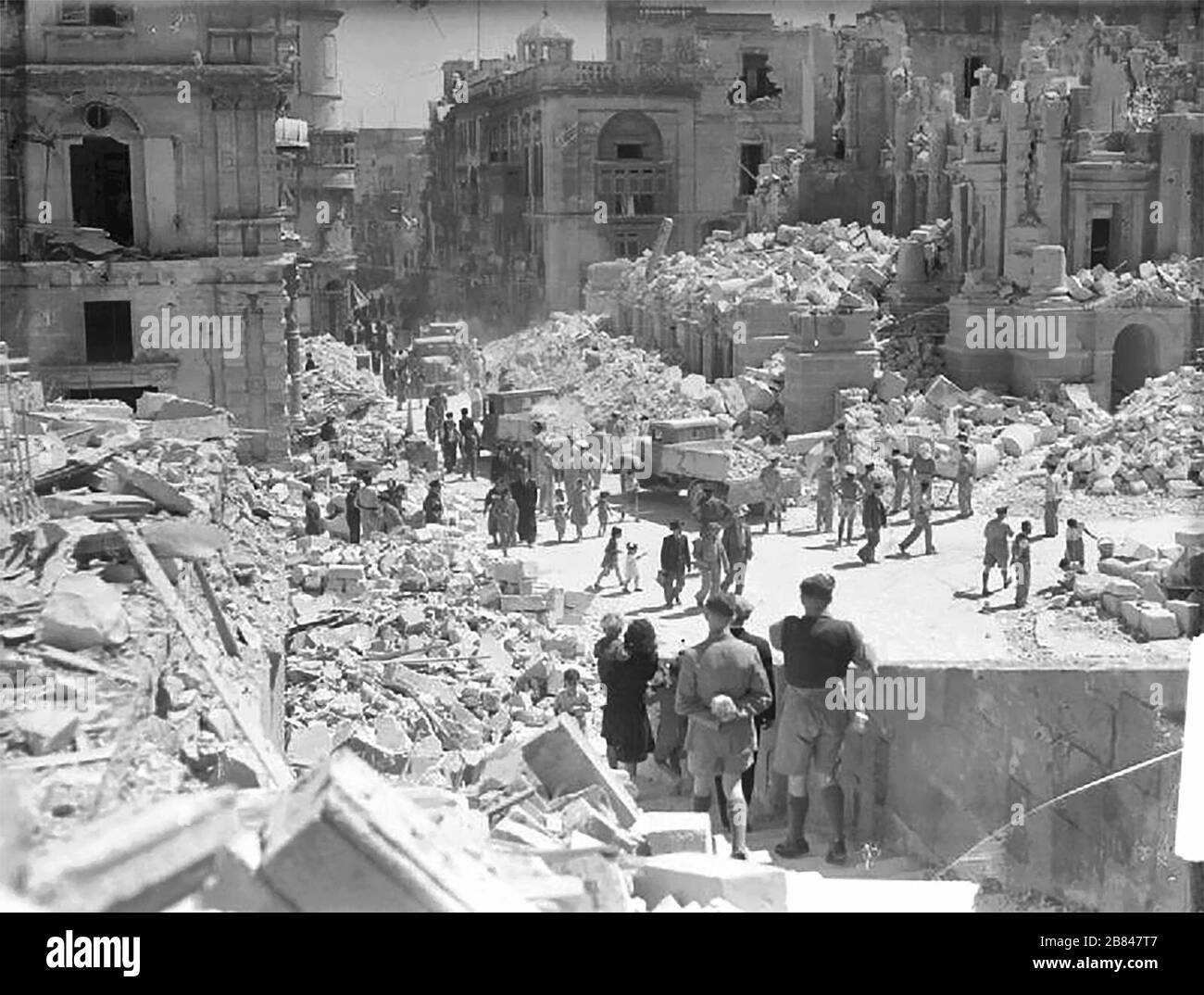 Eine stark bombenbeschädigte Straße in Valletta, Malta. Diese Straße ist Kingsway, die Hauptstraße in Valetta. Das Servicepersonal und Zivilisten beseitigen die Trümmer. April 1942 Stockfoto