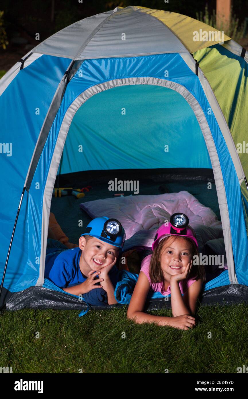 Bruder und Schwester / Spaß im Hinterhofzelt / mit ihren hellen Hüten Stockfoto