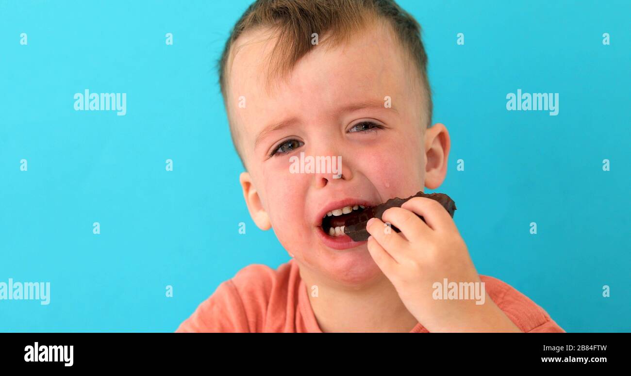 Der kleine Junge ist verärgert, Schokolade zu essen Stockfoto