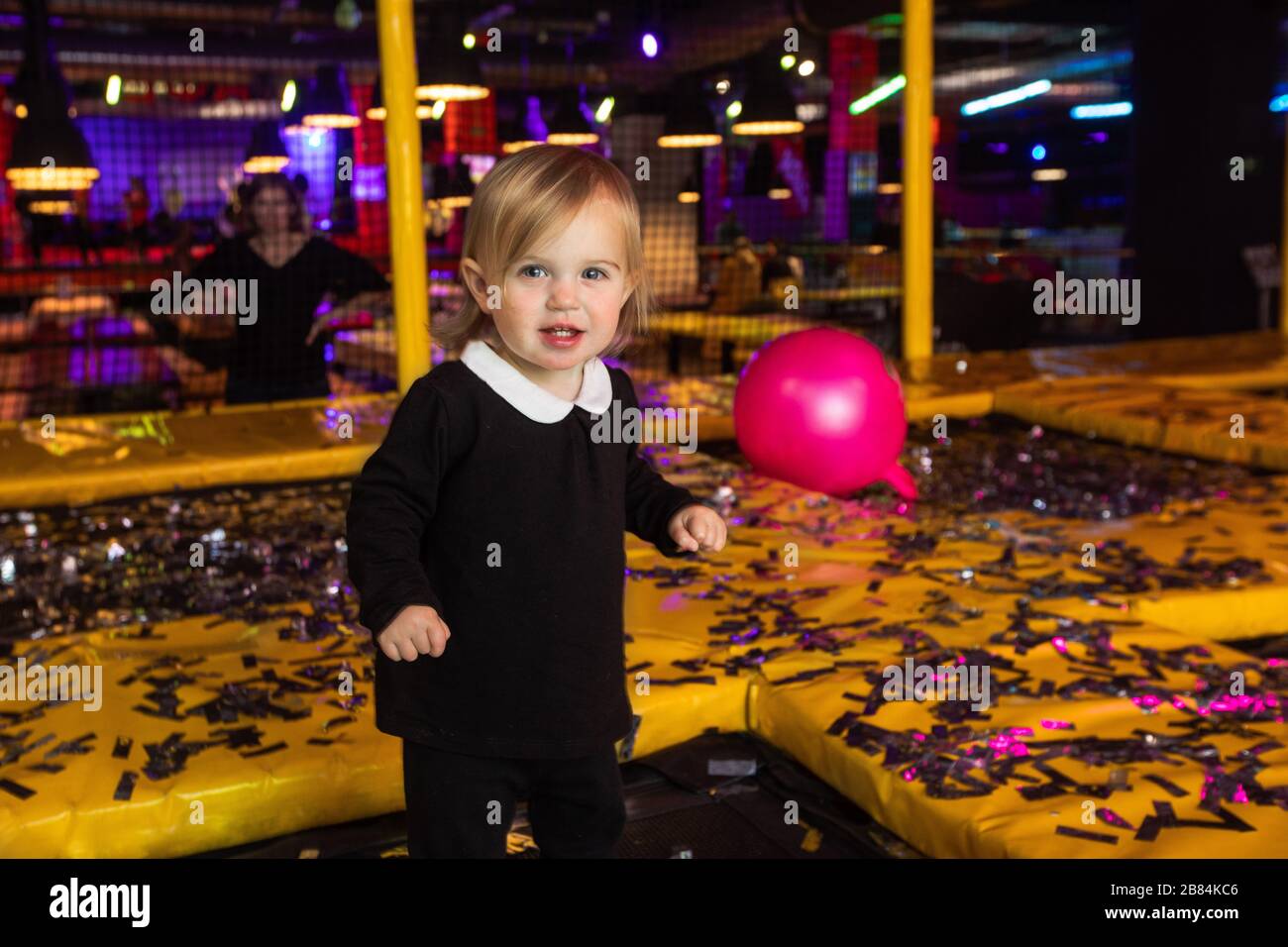 Süßes Mädchen, das während der Party auf Matten spielt Stockfoto