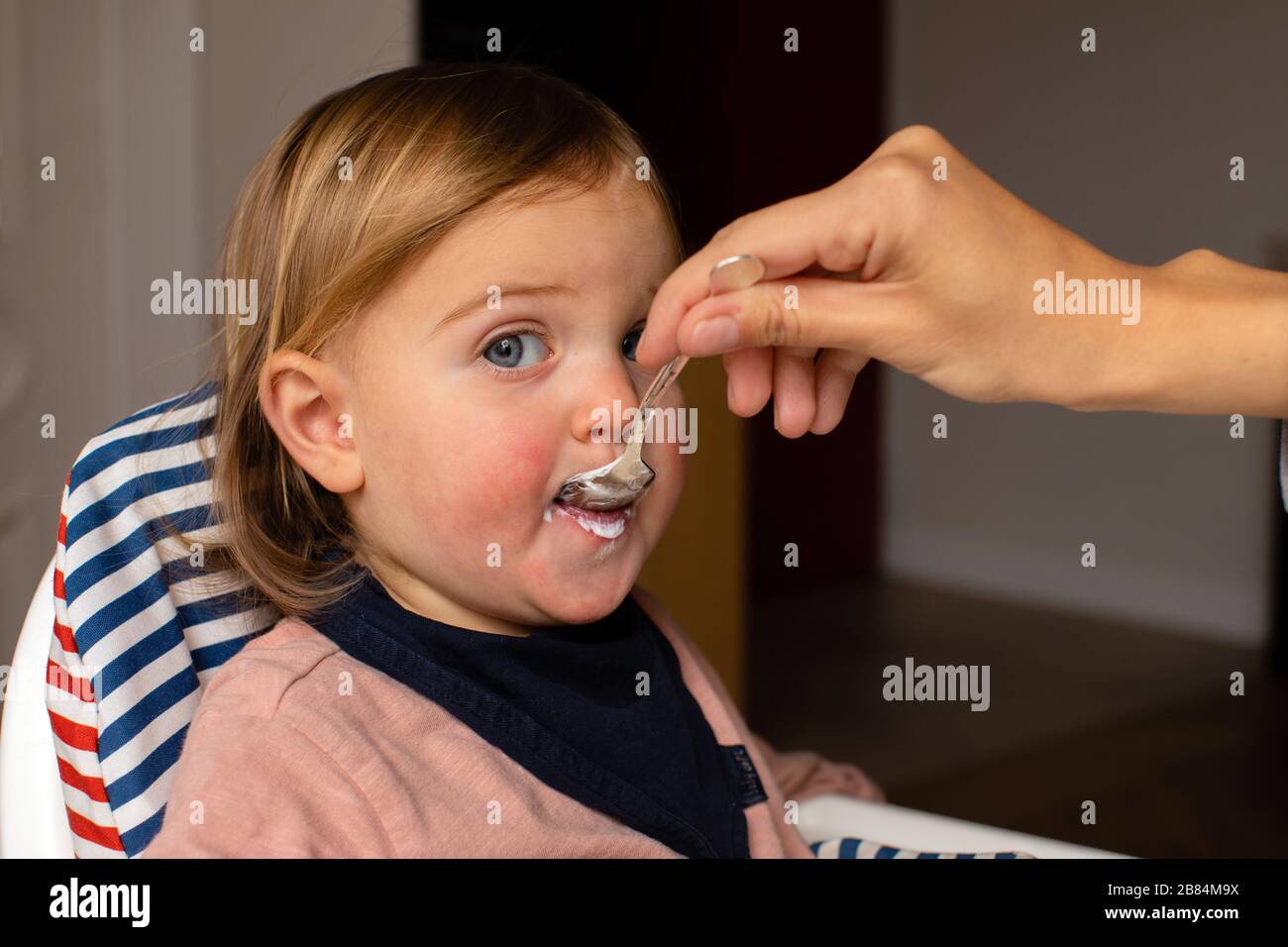 Eltern zuschneiden, die Baby mit Haferbrei füttern Stockfoto