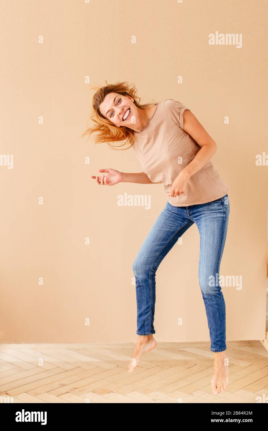 Porträt einer freudigen jungen Frau beim Springen Stockfoto