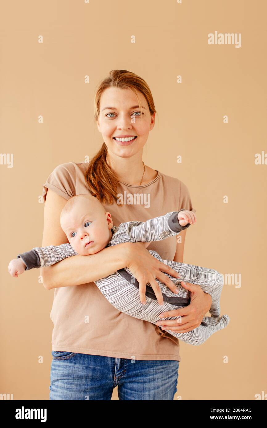 Frau mit Baby in den Händen verlassen, die auf die Kamera blickt Stockfoto