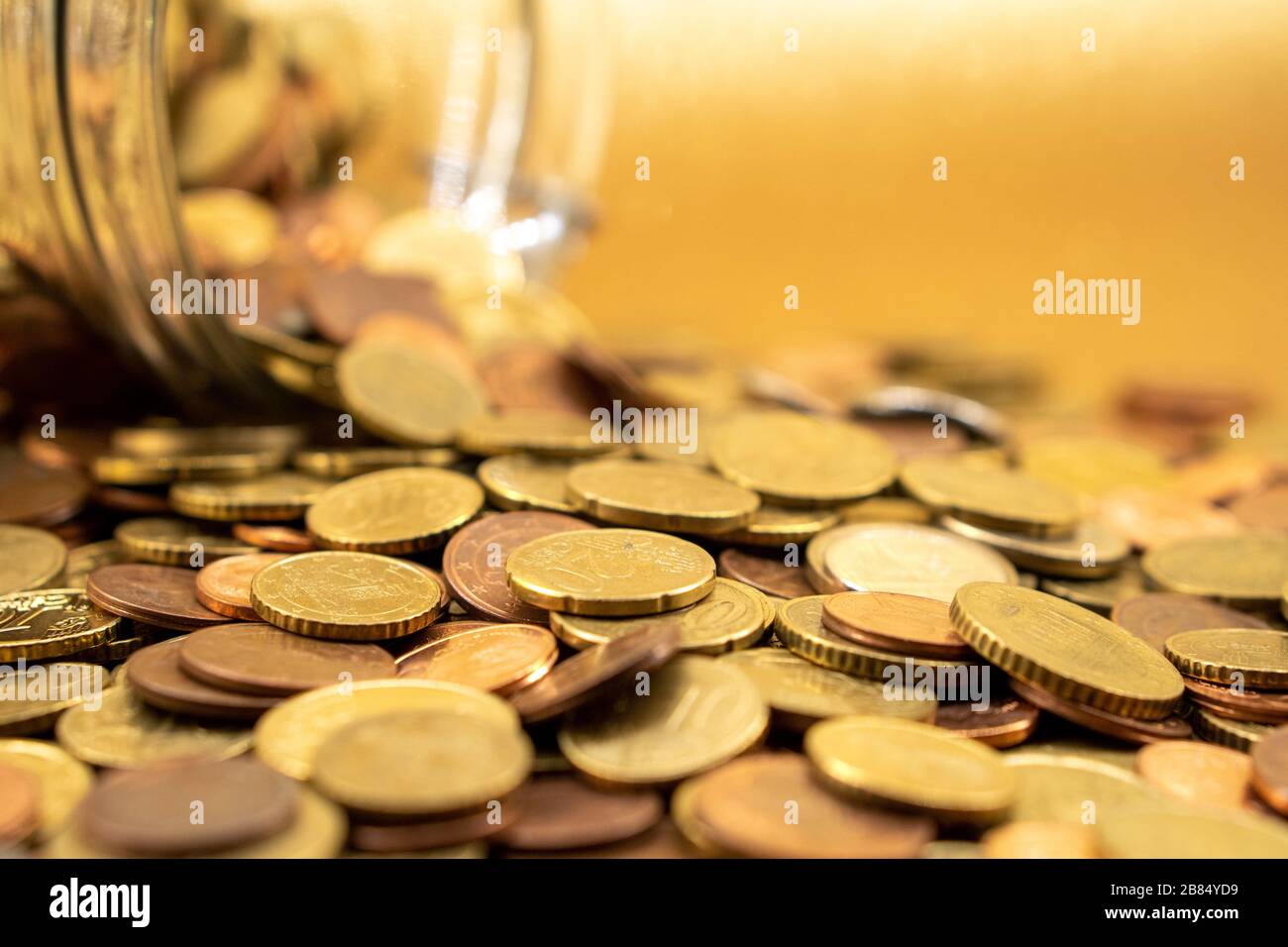 Viele Euromünzen auf goldenem Hintergrund Stockfoto