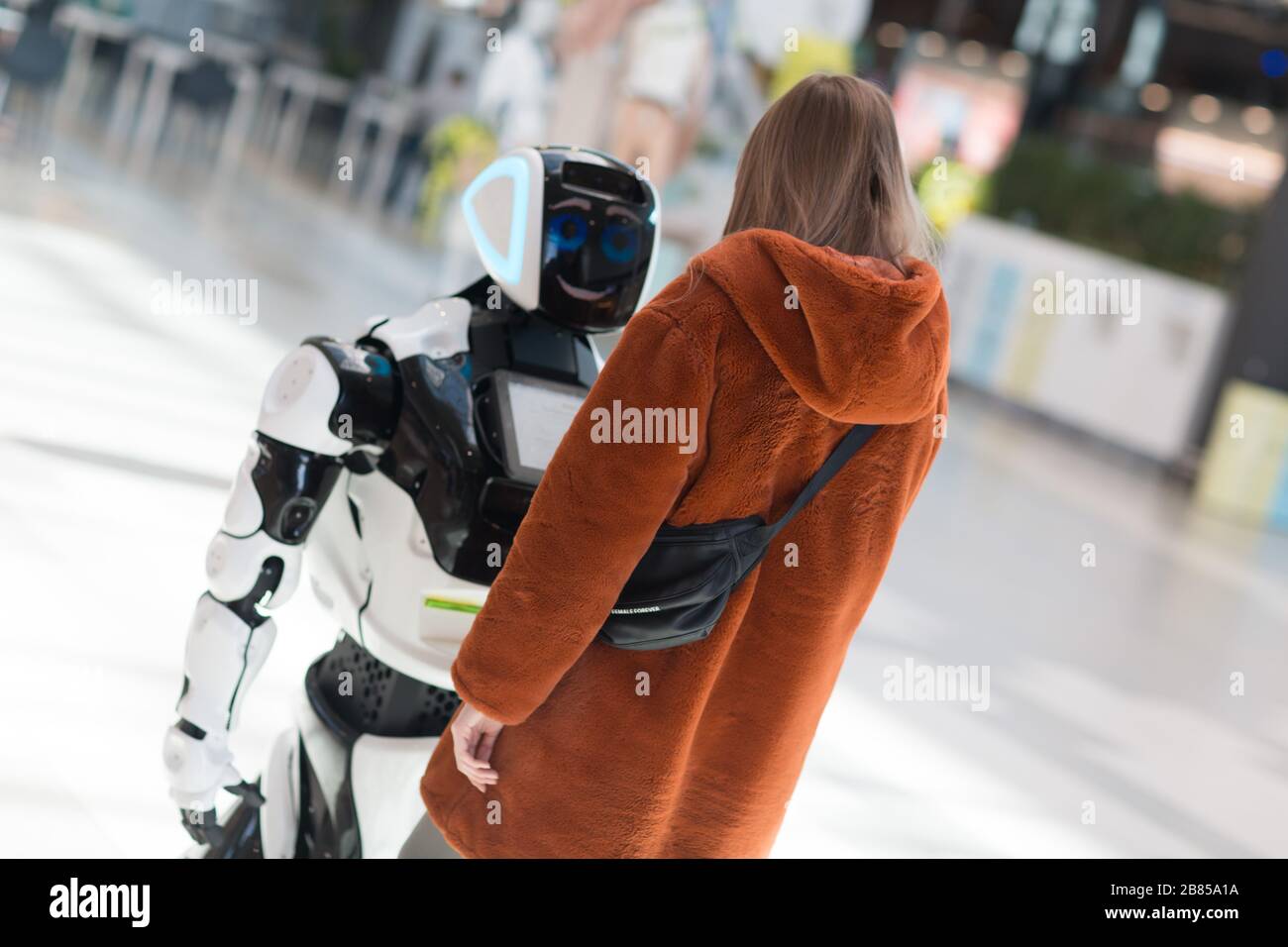 Junge Frau Shopper und Roboterberater im Laden Stockfoto