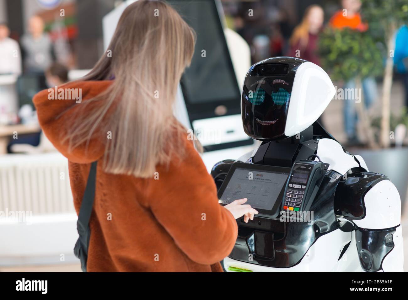 Junge Frau Shopper und Roboterberater im Laden Stockfoto