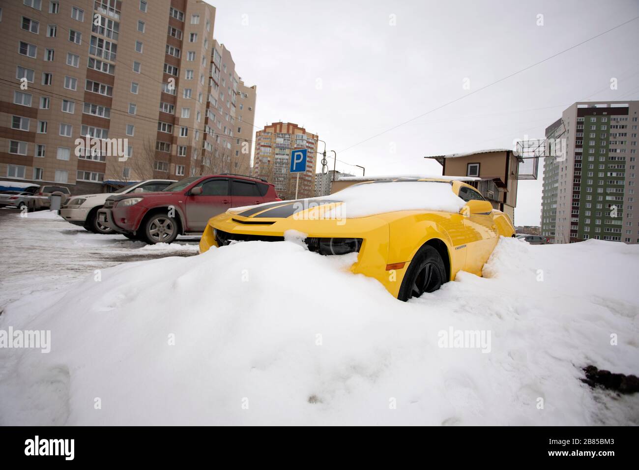 Gelbes Chevrolet Camaro Auto unter Schnee. Omsk, Russland, 29.02.2020 Stockfoto