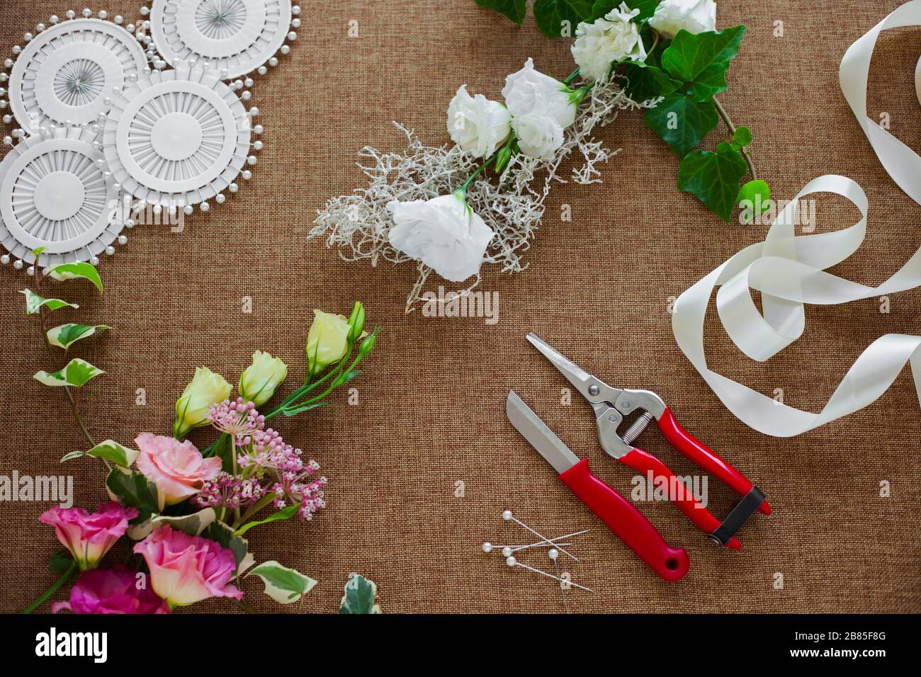 Floristen-Arbeitsplatz. Werkzeuge und Zubehör. Blumen, Pflaugen, Messer, Stifte Stockfoto