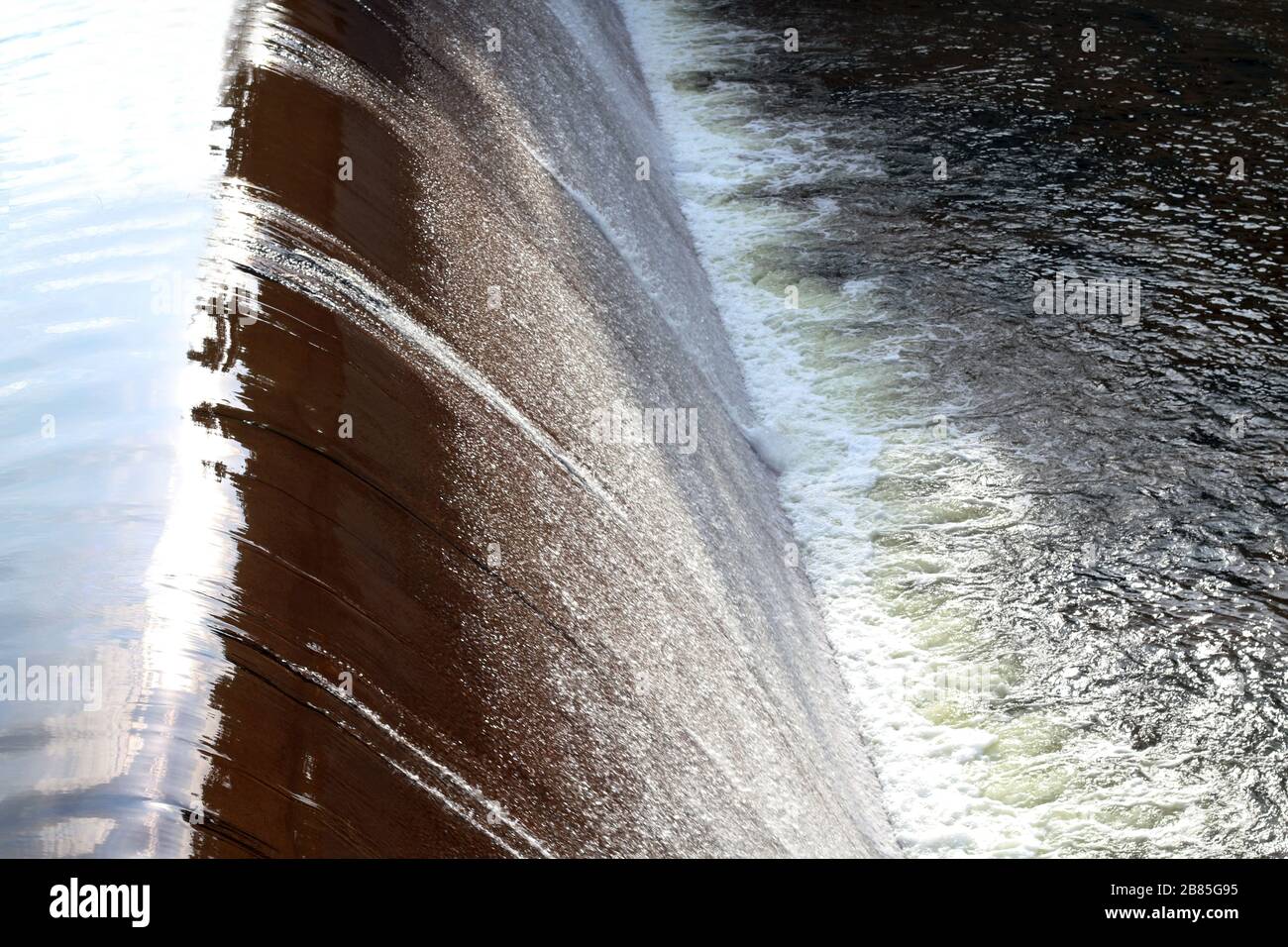 Stauwasserfluss, Oberflächenfluss, Fließwasser am kleinen Wasserreservoir, Staudamm zur Wasserrückhaltung, Spritzwasser, Schwammspray Stockfoto