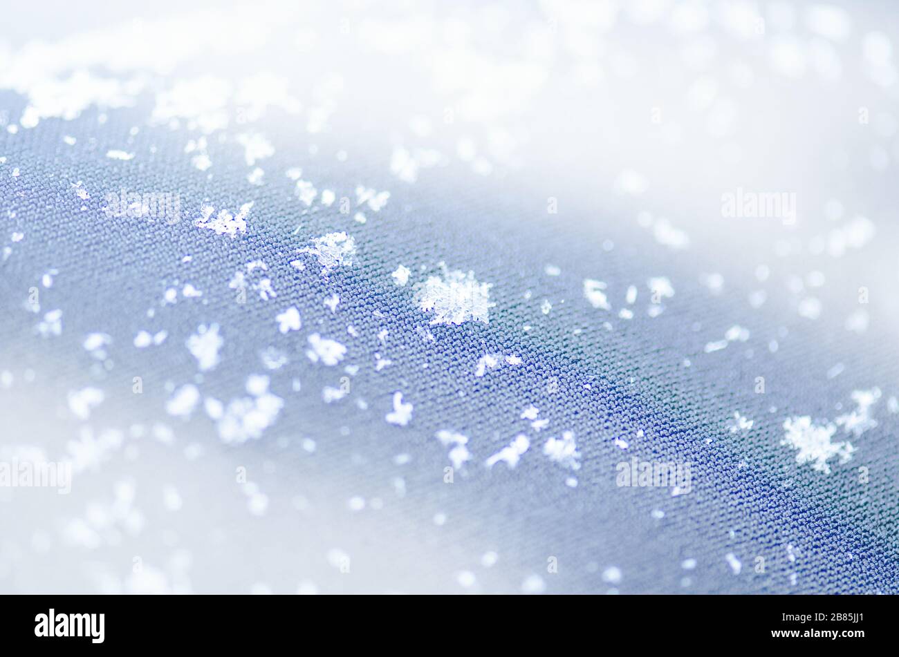 Makro Foto des echten Schnee Kristall. Schneeflocke auf dem blauen Hintergrund. Mode Hintergrund mit weißen Schneeflocken Stockfoto