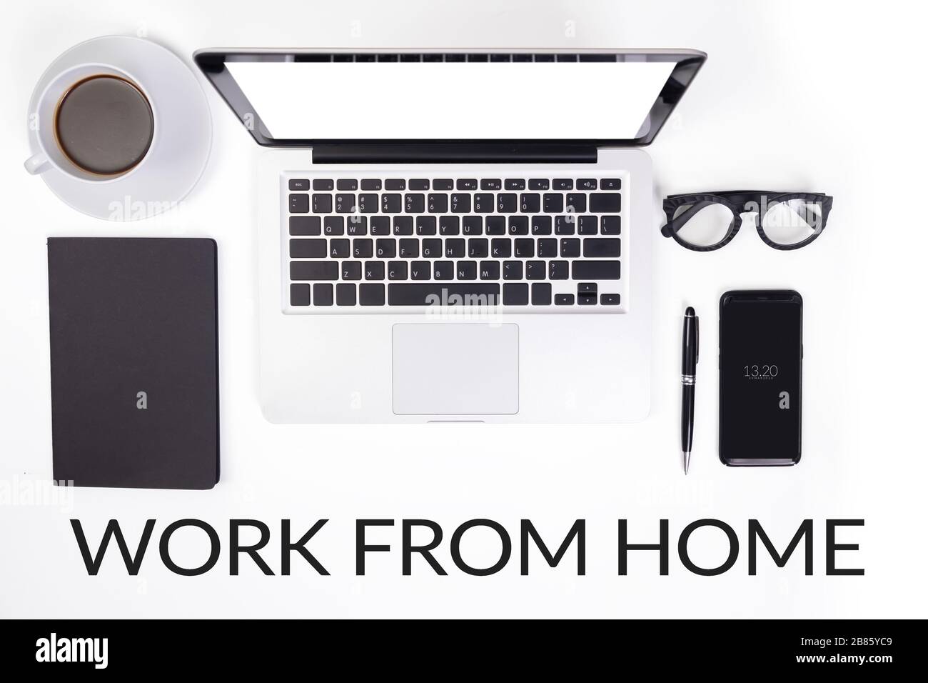 Arbeiten Sie von zu Hause aus. Gerätezubehör auf dem Schreibtisch, z. B. Notebook-Computer, Tasse Kaffee, Brille, Stift, Schreibwaren, Handy Stockfoto