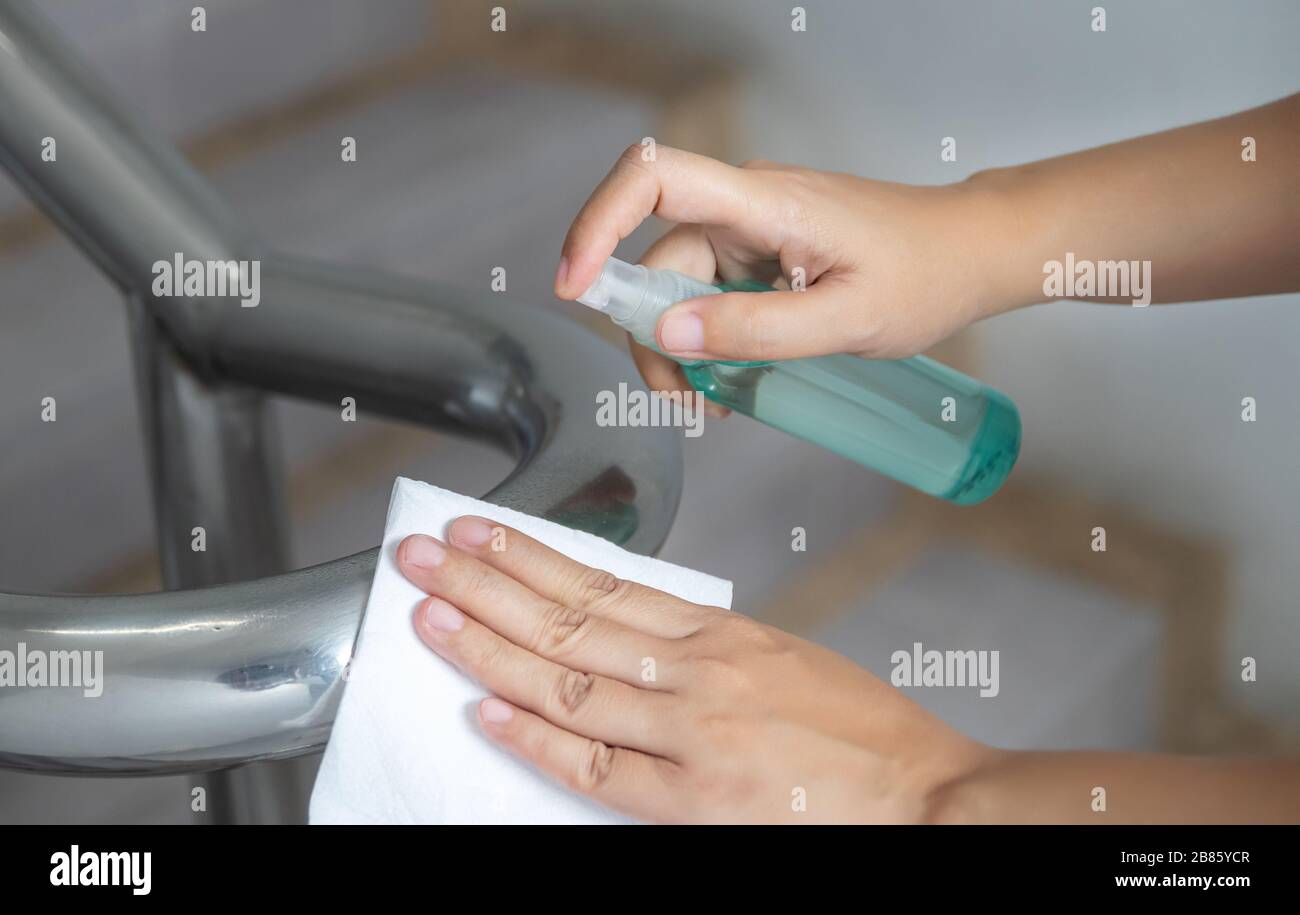 Desinfizieren, desinfizieren, hygienisch pflegen. Reinigungspersonal mit Alkoholspray auf Banister und häufig berührten Bereich zur Reinigung und Desinfektion, Preventio Stockfoto