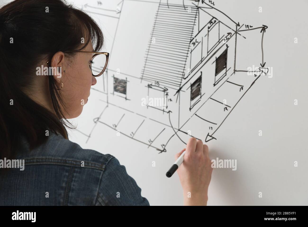 Nahaufnahme einer jungen Architektin, die eine Skizze für ein neues berühmtes Heimprojekt zeichnet. Konzept der Arbeiten an technischen Zeichnungen Stockfoto