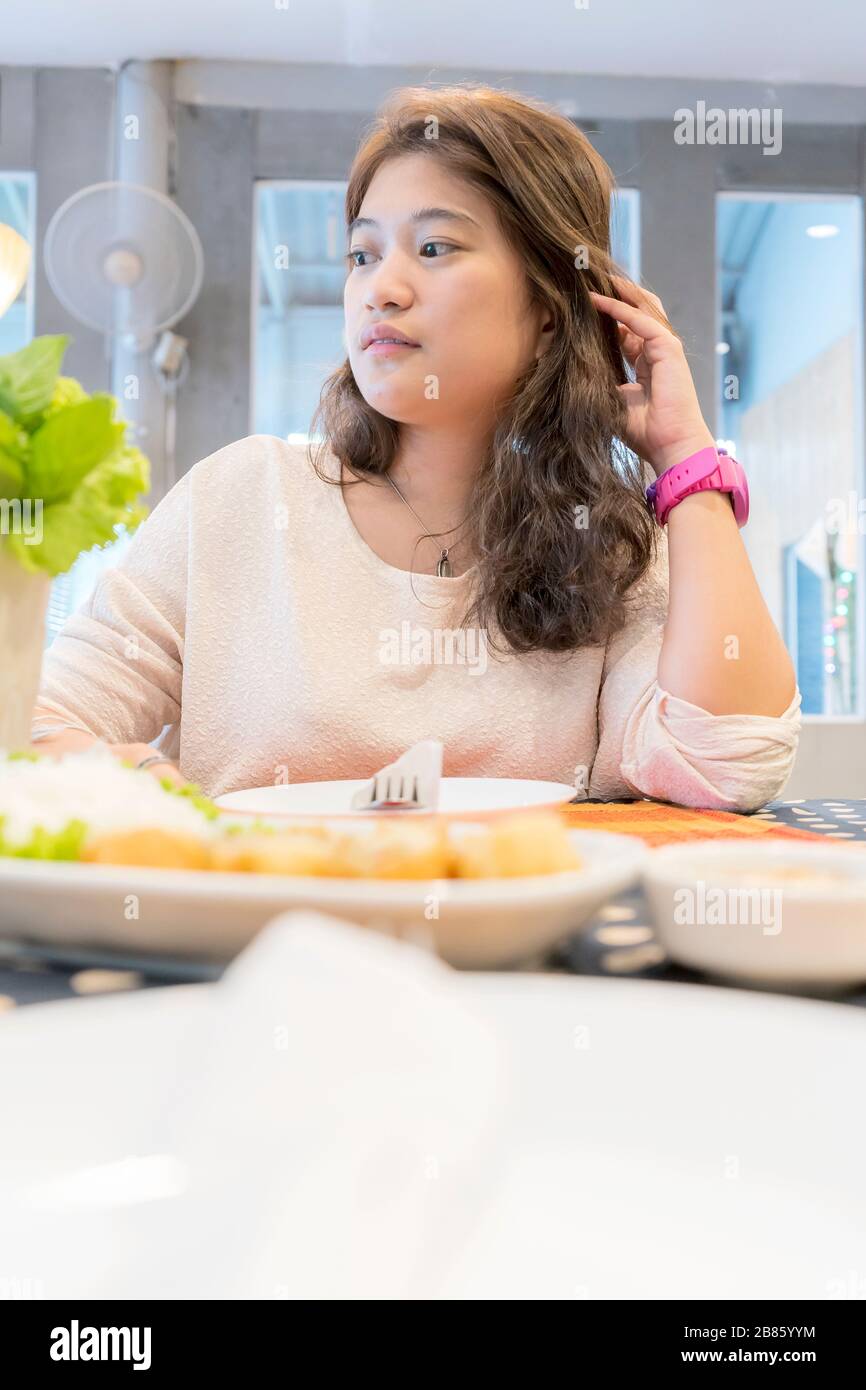 Asiatische Frauen essen Essen, sitzen in einem Restaurant, Frontszene mit Essen platziert. Stockfoto