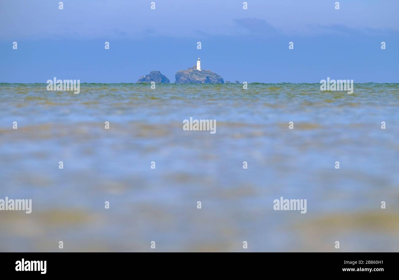Niedriger Schuss von strahlend blaugrünem Meer mit Godrevy Lighthouse im Hintergrund Stockfoto