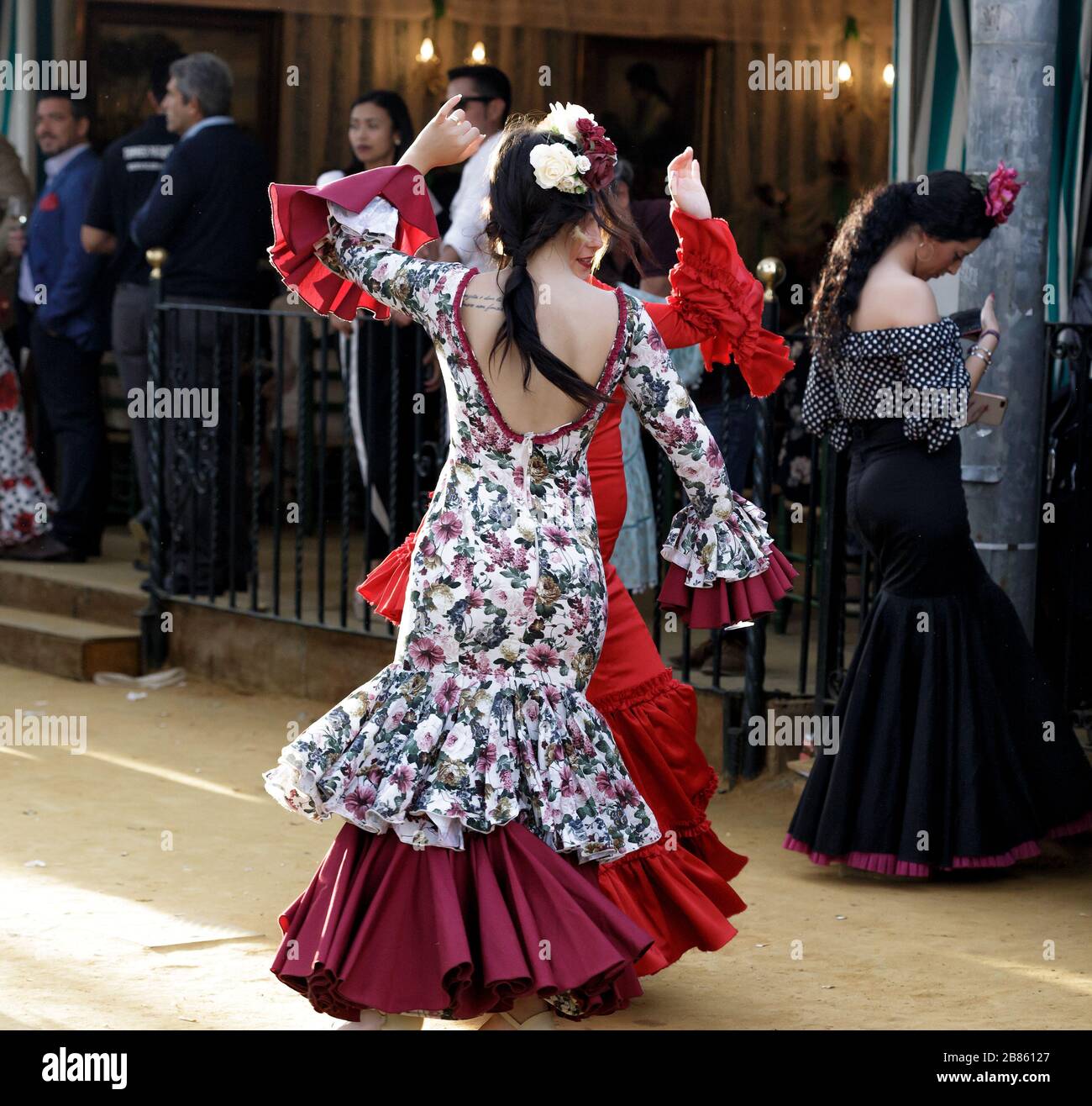 Junge Frauen, die Flamenco-Kleider tragen und auf der Aprilmesse (Feria de  Abril), der Messe von Sevilla, "Sevillanas" tanzen Stockfotografie - Alamy