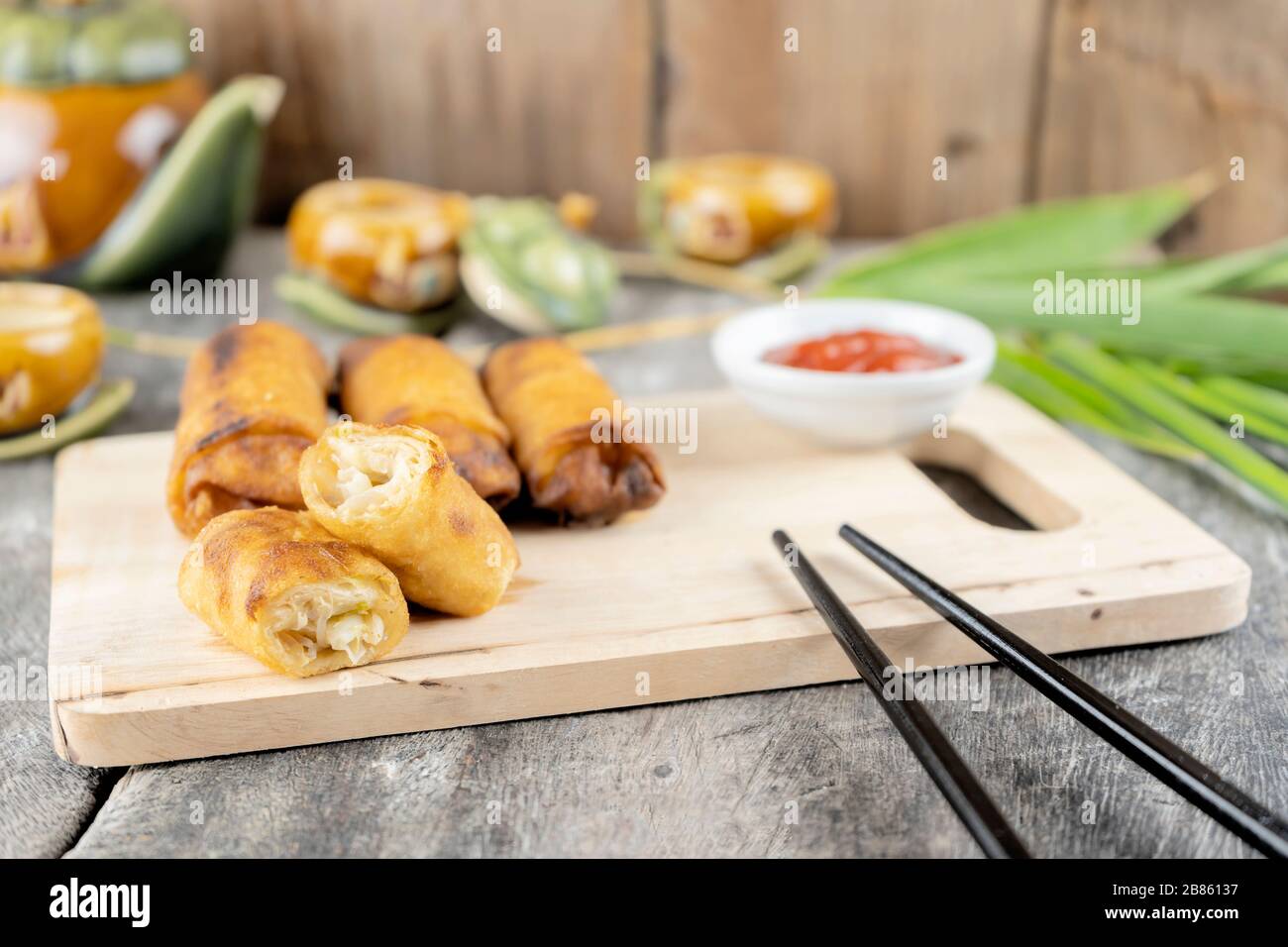 Frühlingsrollen stammen aus dem chinesischen, die wir im Menü Dim Sum gegessen haben. Die ursprüngliche Füllung ist Hackfleisch Schweinefleisch vermicelli. Auf der Seite aufgestellte Essstäbchen Stockfoto