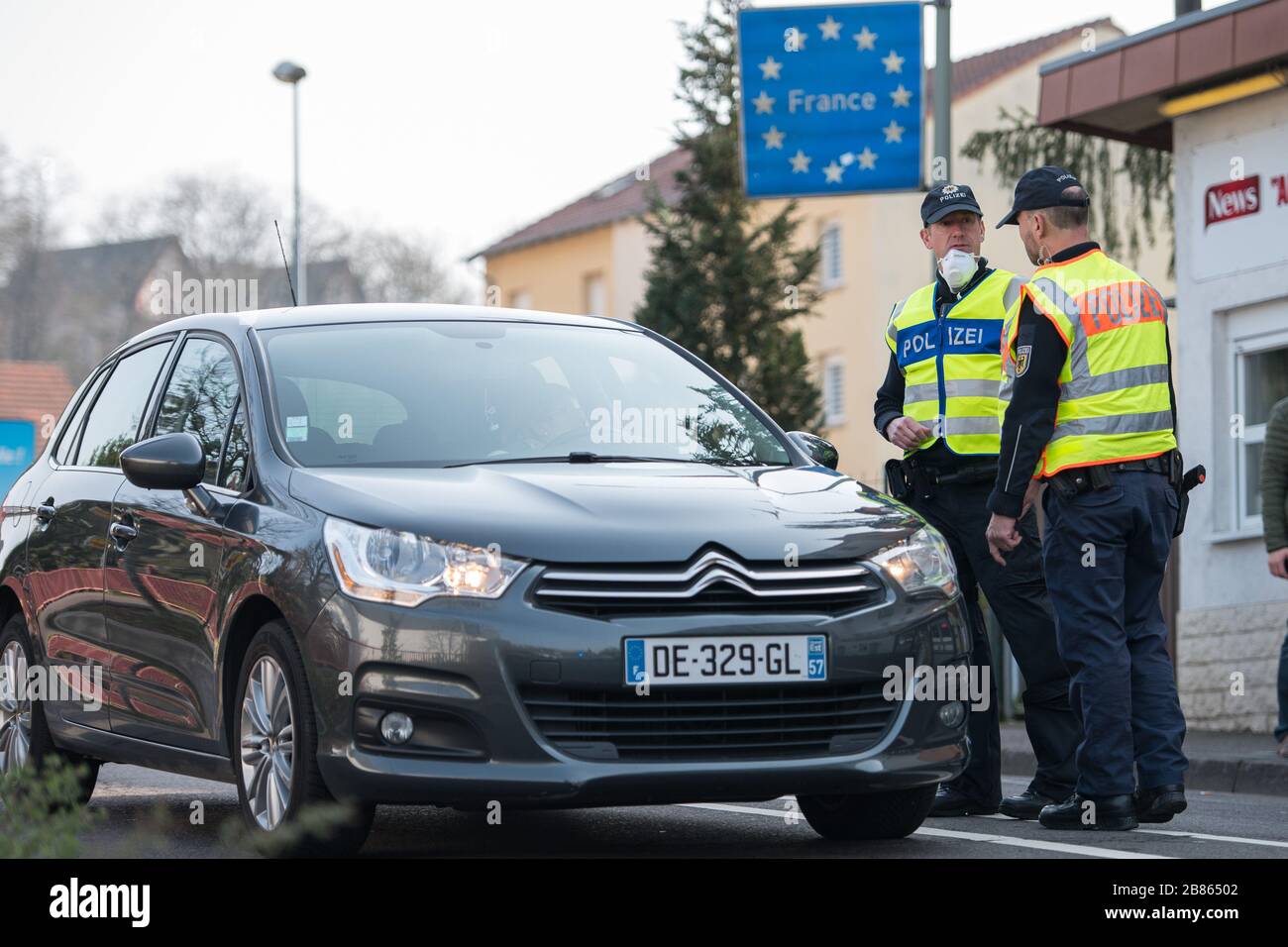 20. März 2020, Saarland, Großrosseln: Beamte der Bundespolizei kontrollieren ein französisches Fahrzeug, das von Petite-Rossell in Frankreich nach Großrosseln im Saarland fahren will. Nur wer nachweisen kann, dass er in Deutschland arbeitet, darf die Grenze überschreiten, die wegen der Ausbreitung des Coronavirus gesperrt ist. Foto: Oliver Dietze / dpa Stockfoto