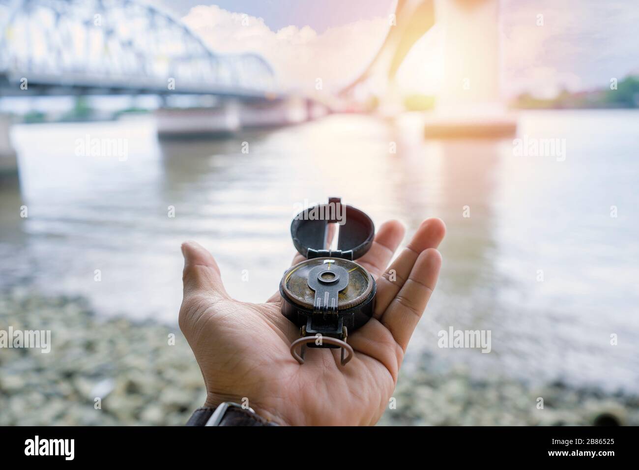 Kompass, Navigationskompass, Kompass, Kompass verloren, Hintergrund ist eine Brücke für anspruchsvolle Reisen. Der große Fluss ist wie ein Hindernis. Stockfoto