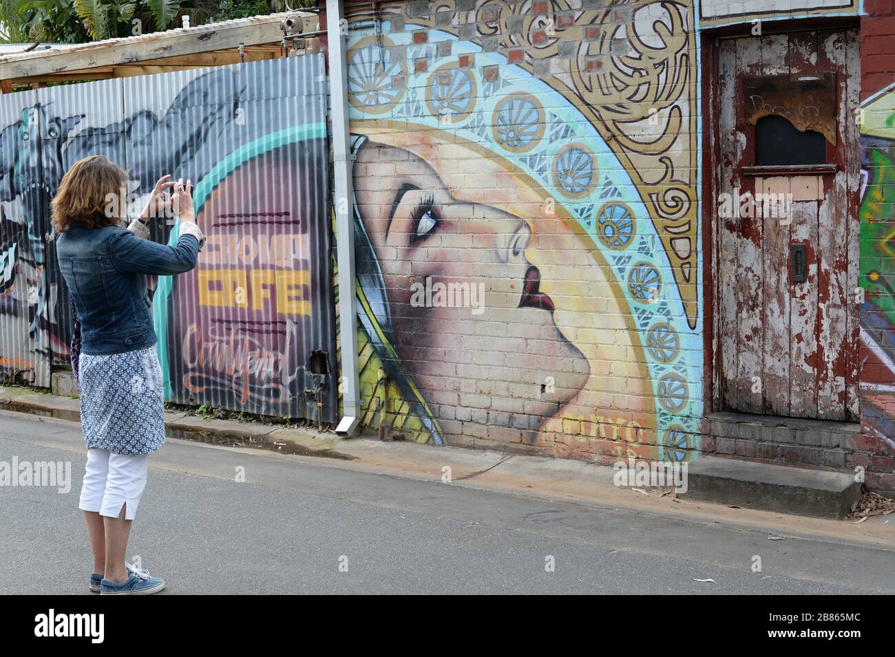 Frau fotografiert einige der farbenfrohen Straßenkunst, die in Melbourne, Australien zu finden ist Stockfoto