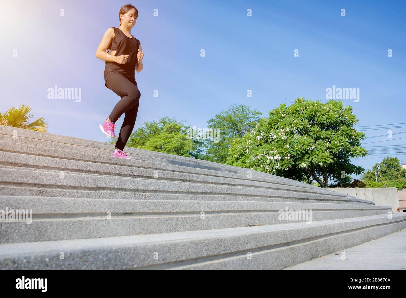 Fitness Sport Konzept, Frau in der Mode Sportbekleidung, Fitness Übung in der Stadt Straße über grauer Beton Hintergrund. Outdoor Sport Kleidung ein Stockfoto