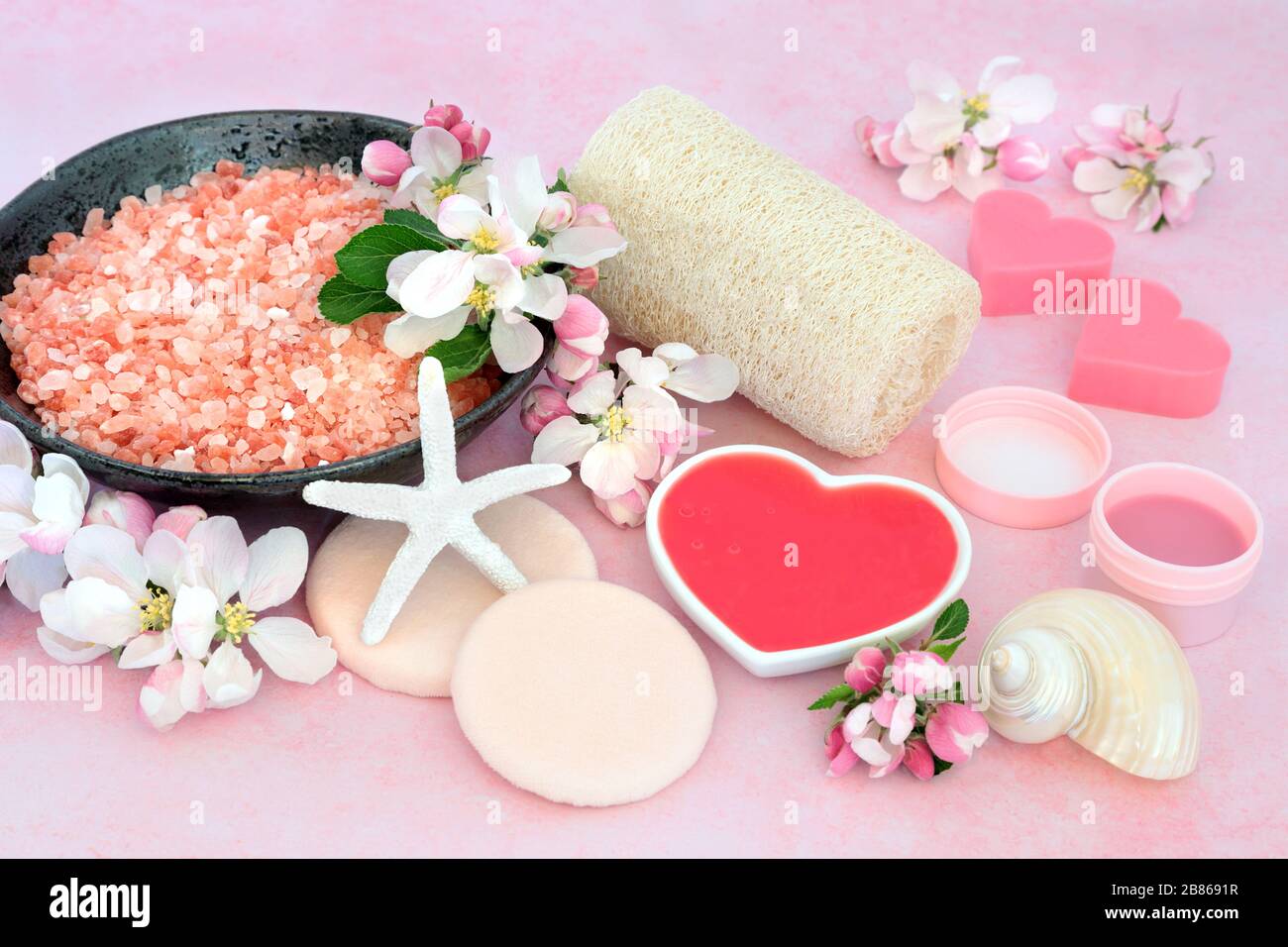 Vegane Hautpflege Spa-Beauty-Behandlung mit ehemaligen Foliation- und Reinigungsprodukten mit apfelblütenblumen auf Pink. Anti-Aging-Konzept für die Gesundheitsversorgung. Stockfoto
